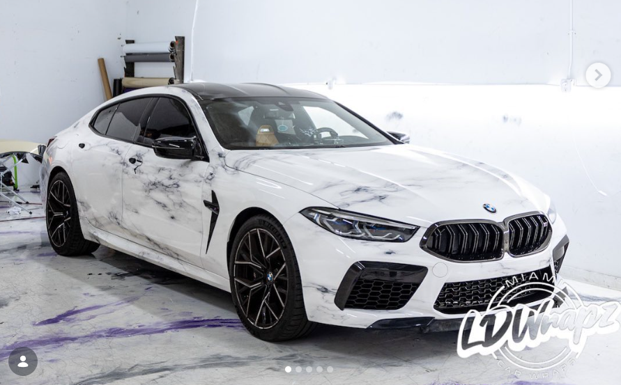 Luxury home featuring white painted brick and arched carriage house style garage doors